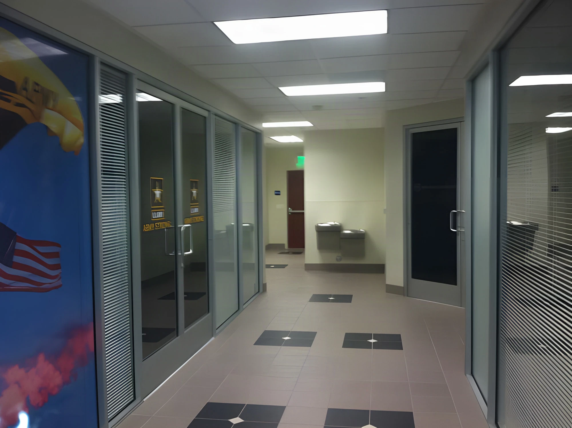 Glass-fronted private offices along a tiled corridor in the Armed Forces Career Center