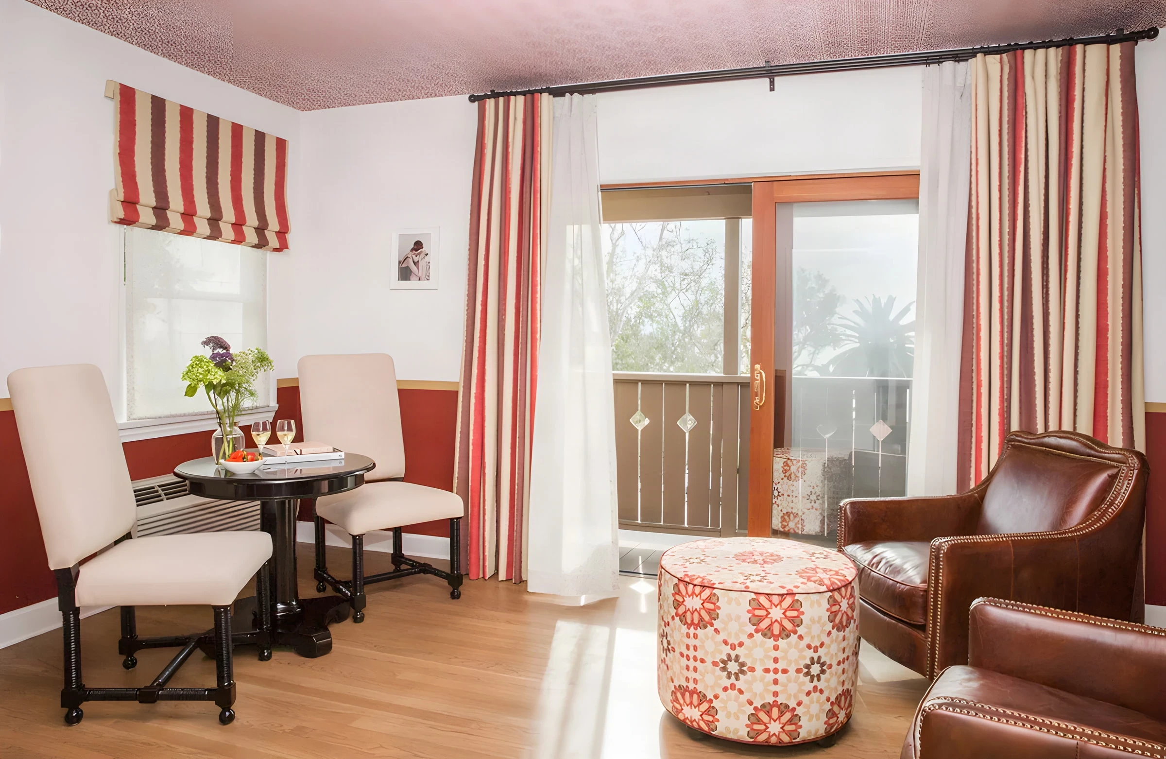 Casa Laguna sitting room with striped drapes and a balcony door onto the trees