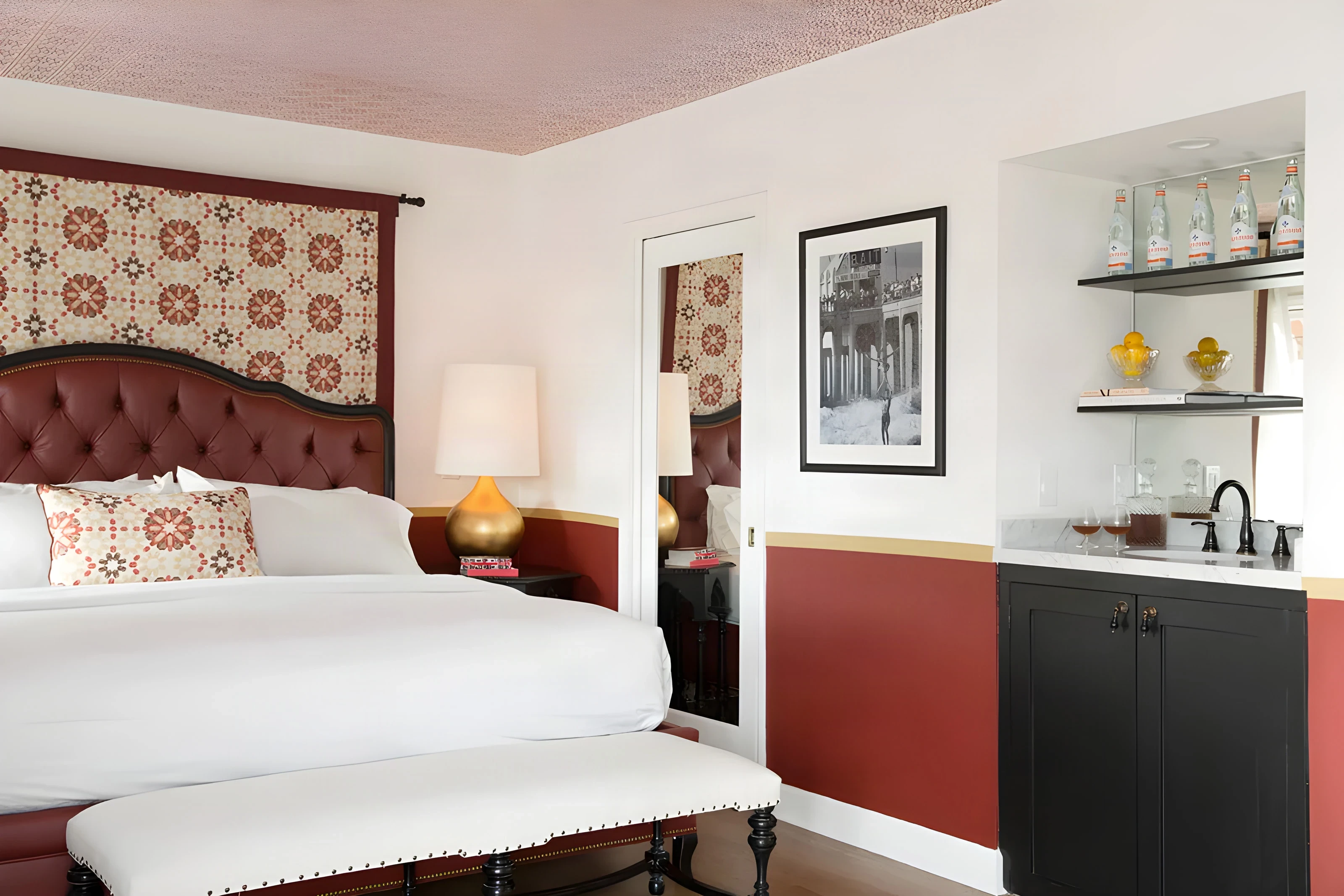 Guest bed with a patterned headboard and a black wet bar at Casa Laguna Inn & Spa