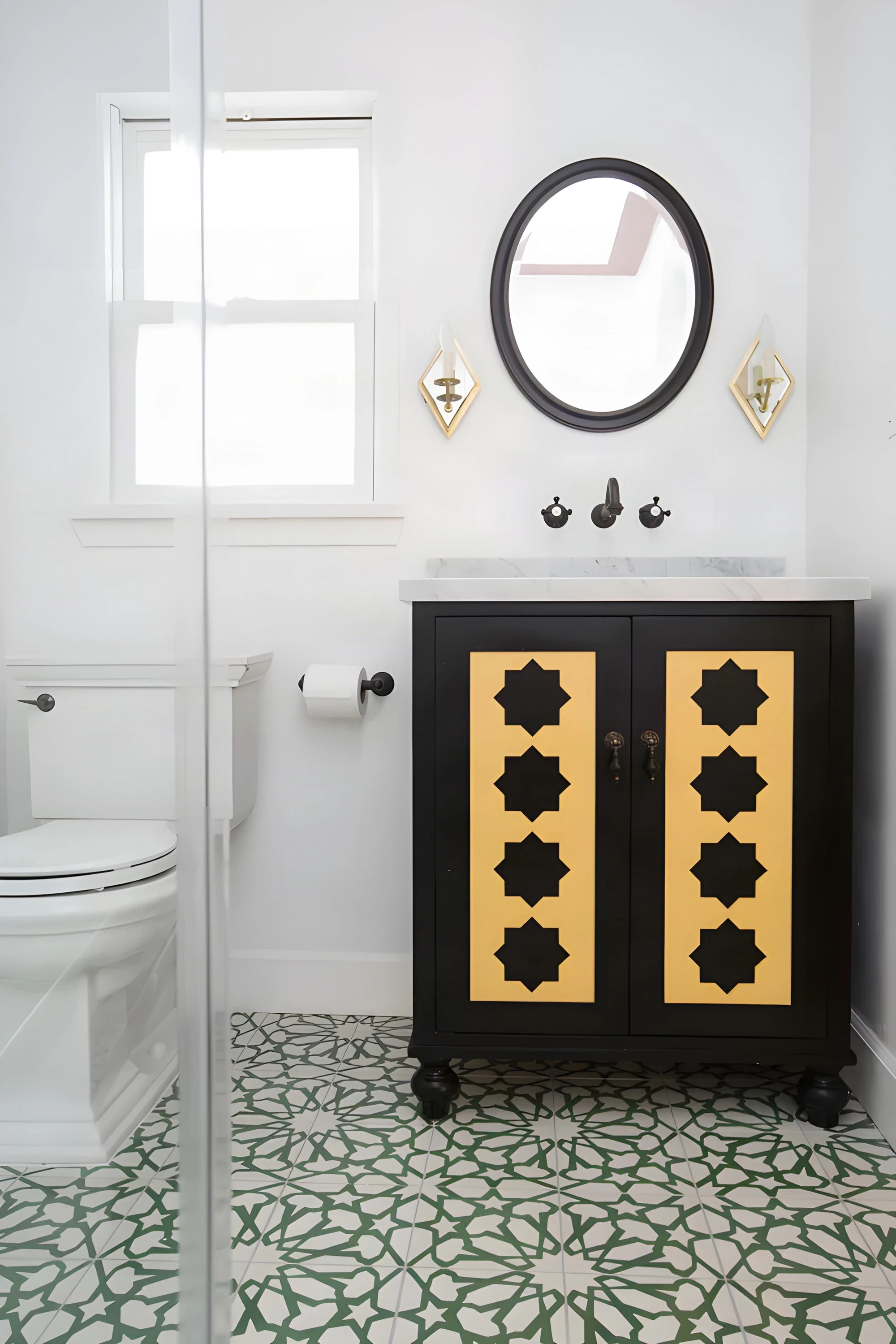 Casa Laguna bath with a black vanity, round mirror and green cement tile floor