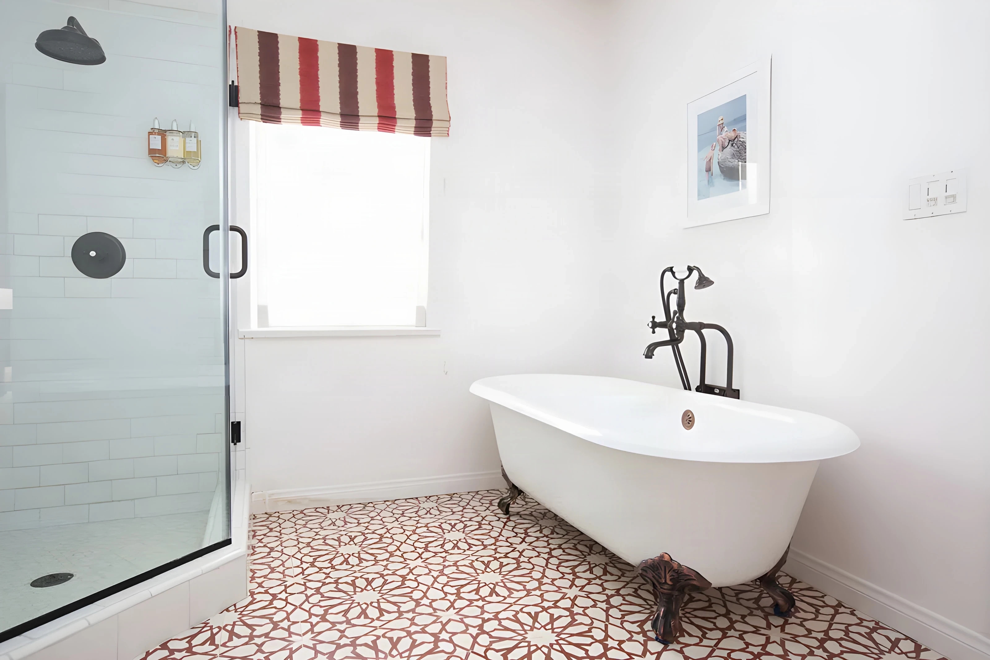 Clawfoot tub on red patterned tile beside a glass shower at Casa Laguna