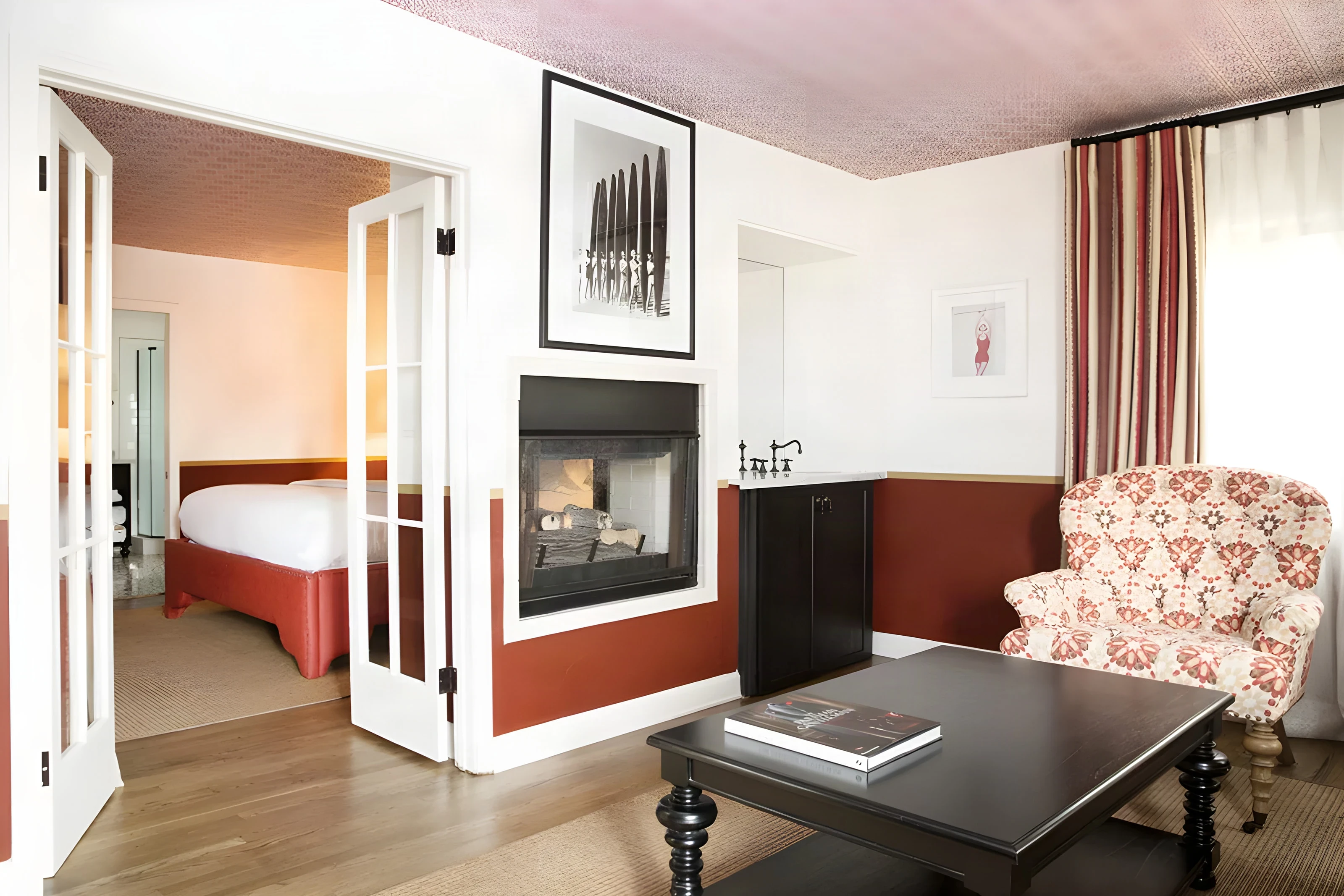 Casa Laguna suite with a see-through fireplace, French doors and a floral armchair