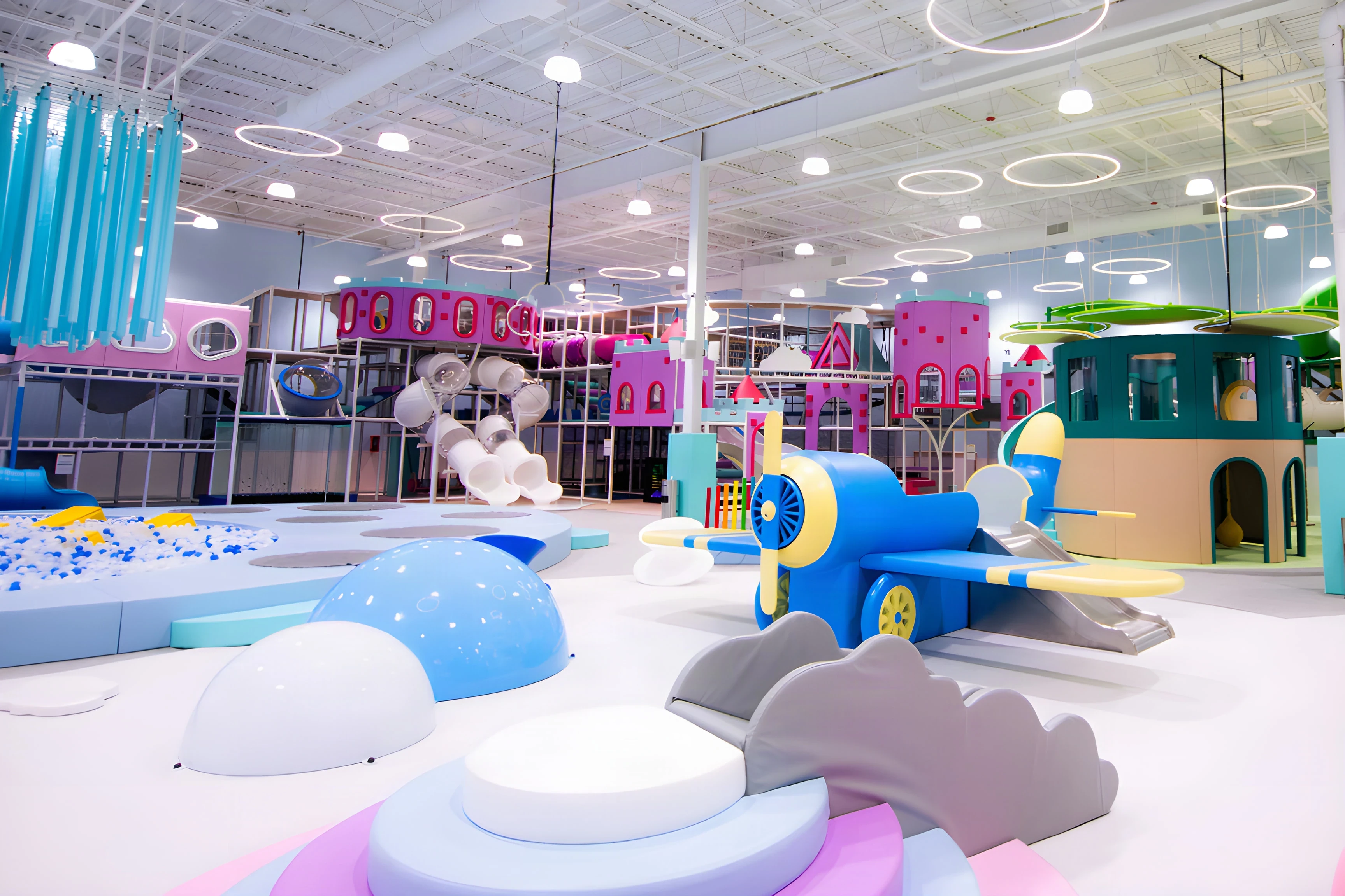 Cloudbound play floor with a blue airplane slide, soft clouds and pastel play towers