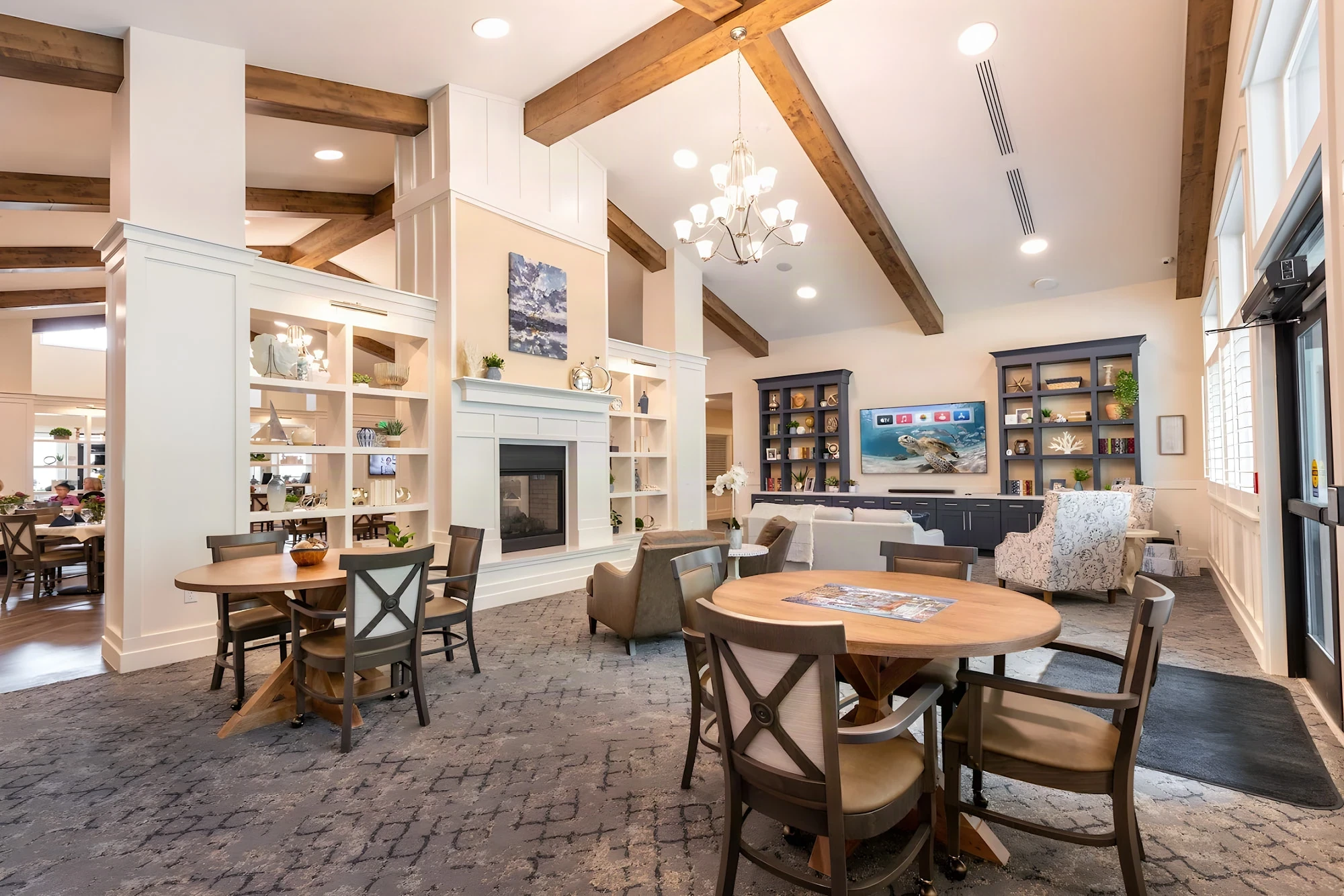 Great room with timber beams, a chandelier and game tables at The Covington