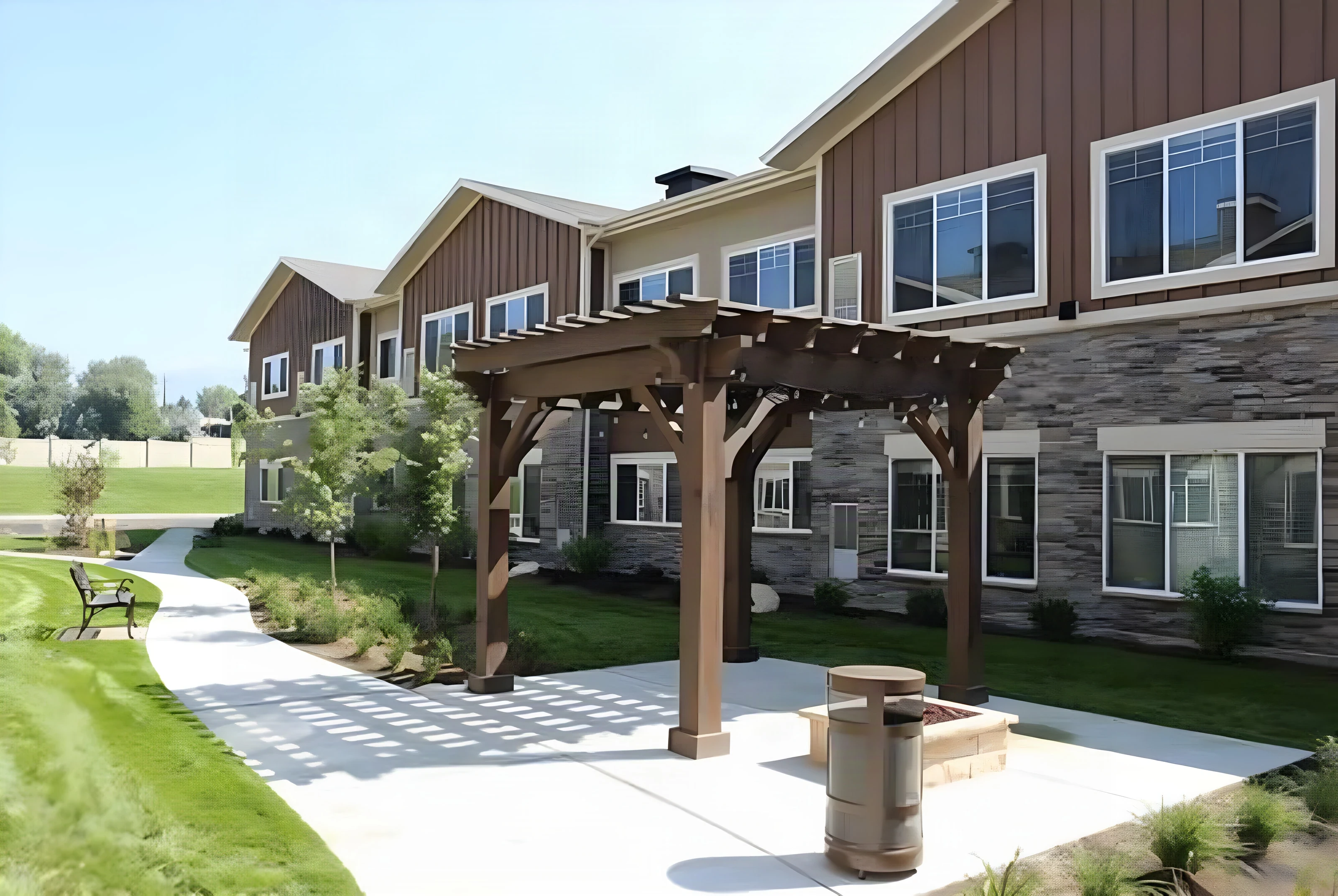 New timber pergola and fire feature beside stone-clad buildings at The Covington