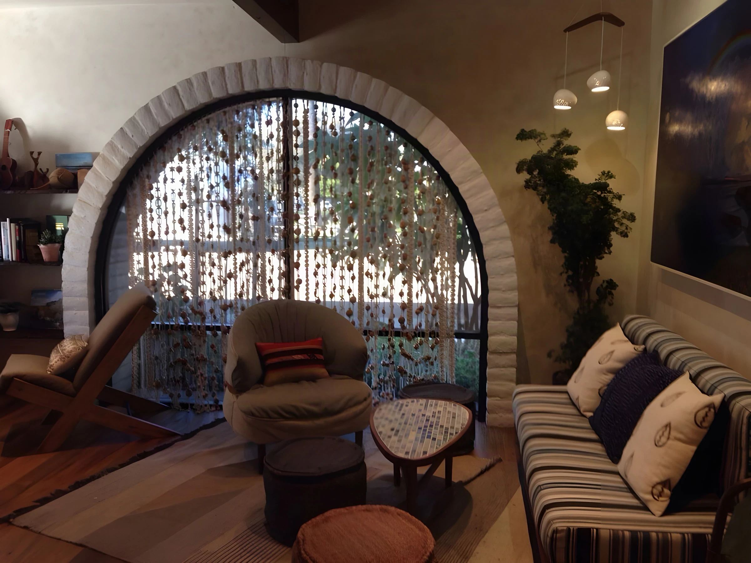 Lounge corner at The Good Bar with a beaded curtain over an arched brick window and pendant lights