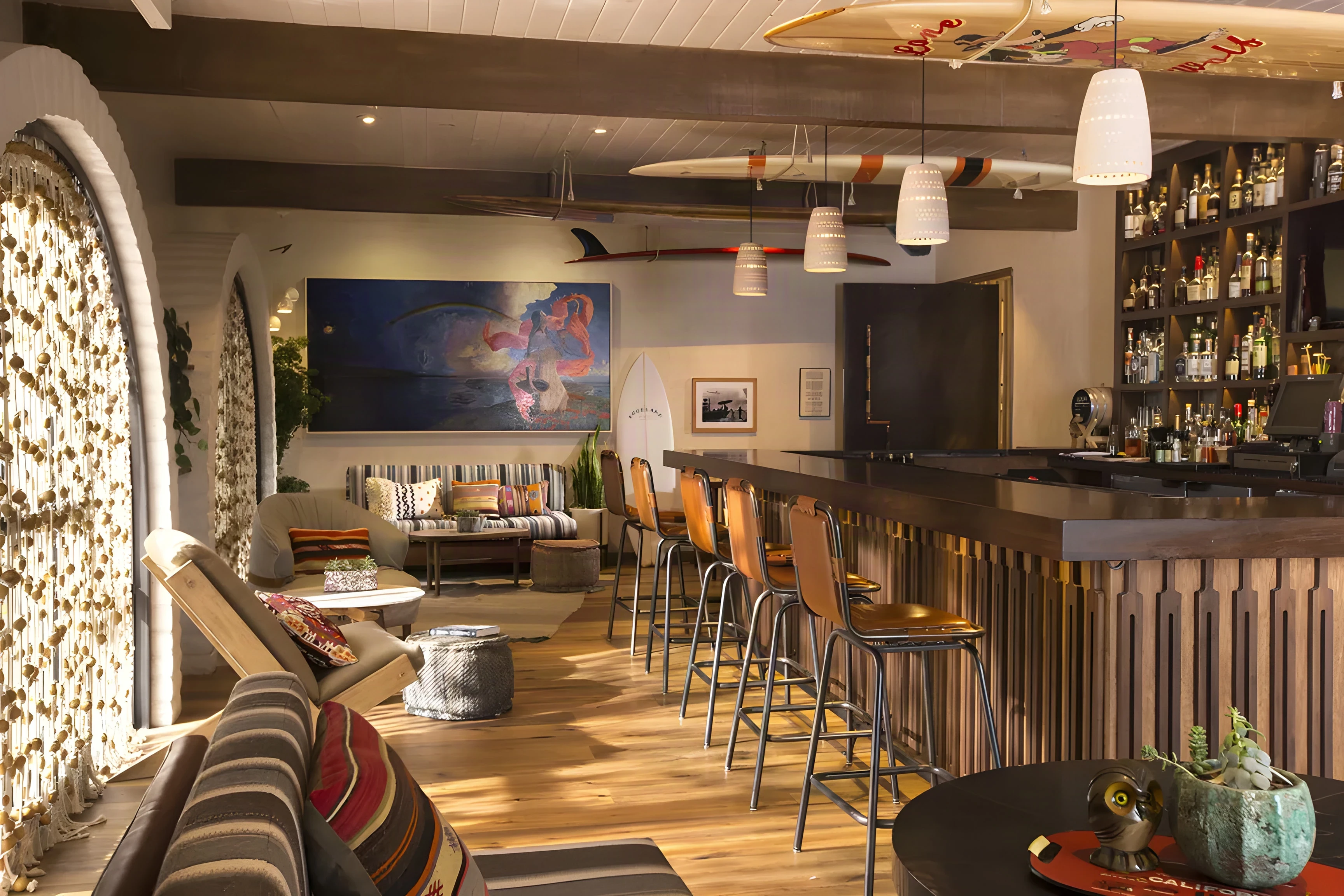 The Good Bar with a long timber counter, surfboards overhead and lantern pendants
