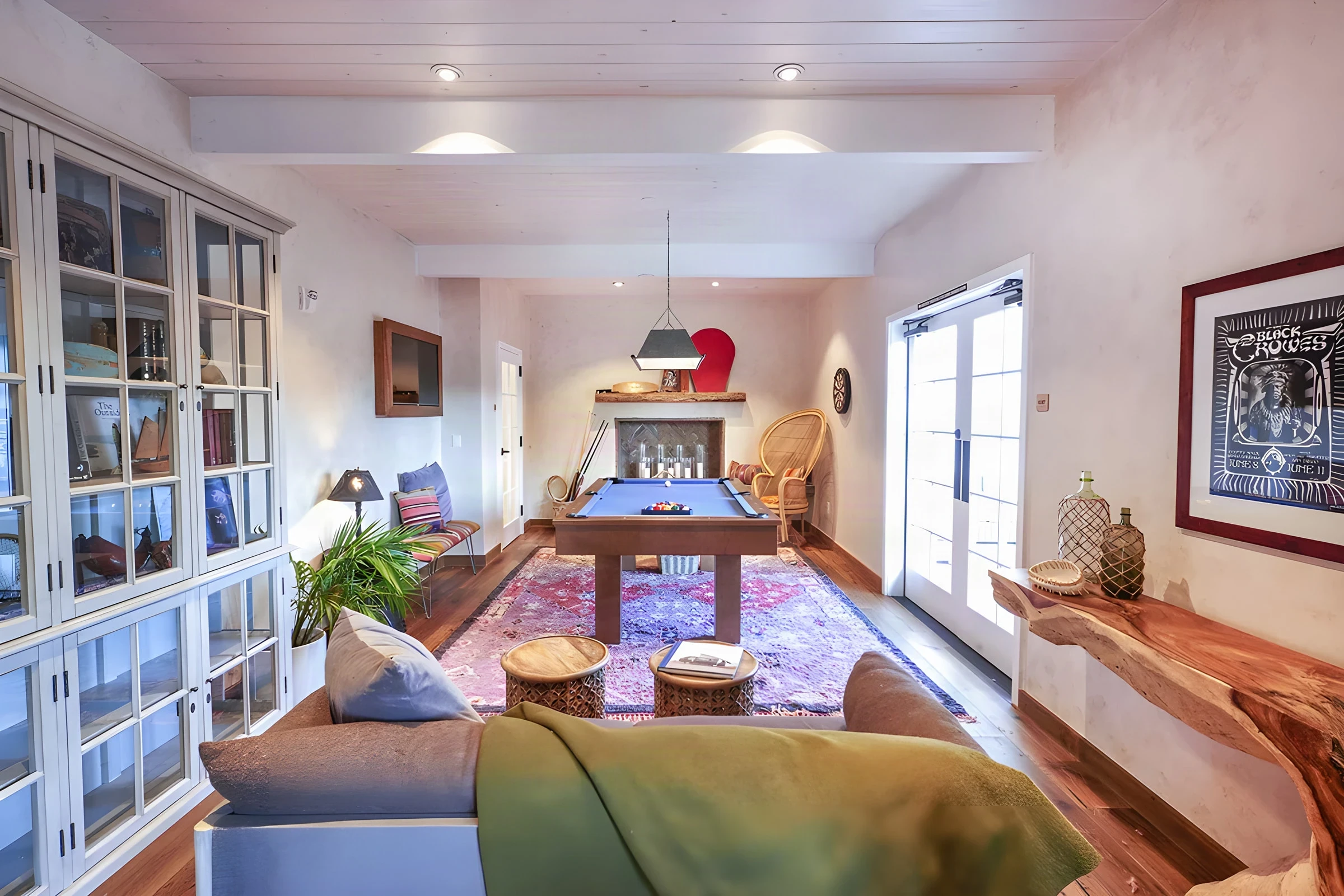 Lounge at The Good Bar with a pool table, patterned rug and glass cabinets