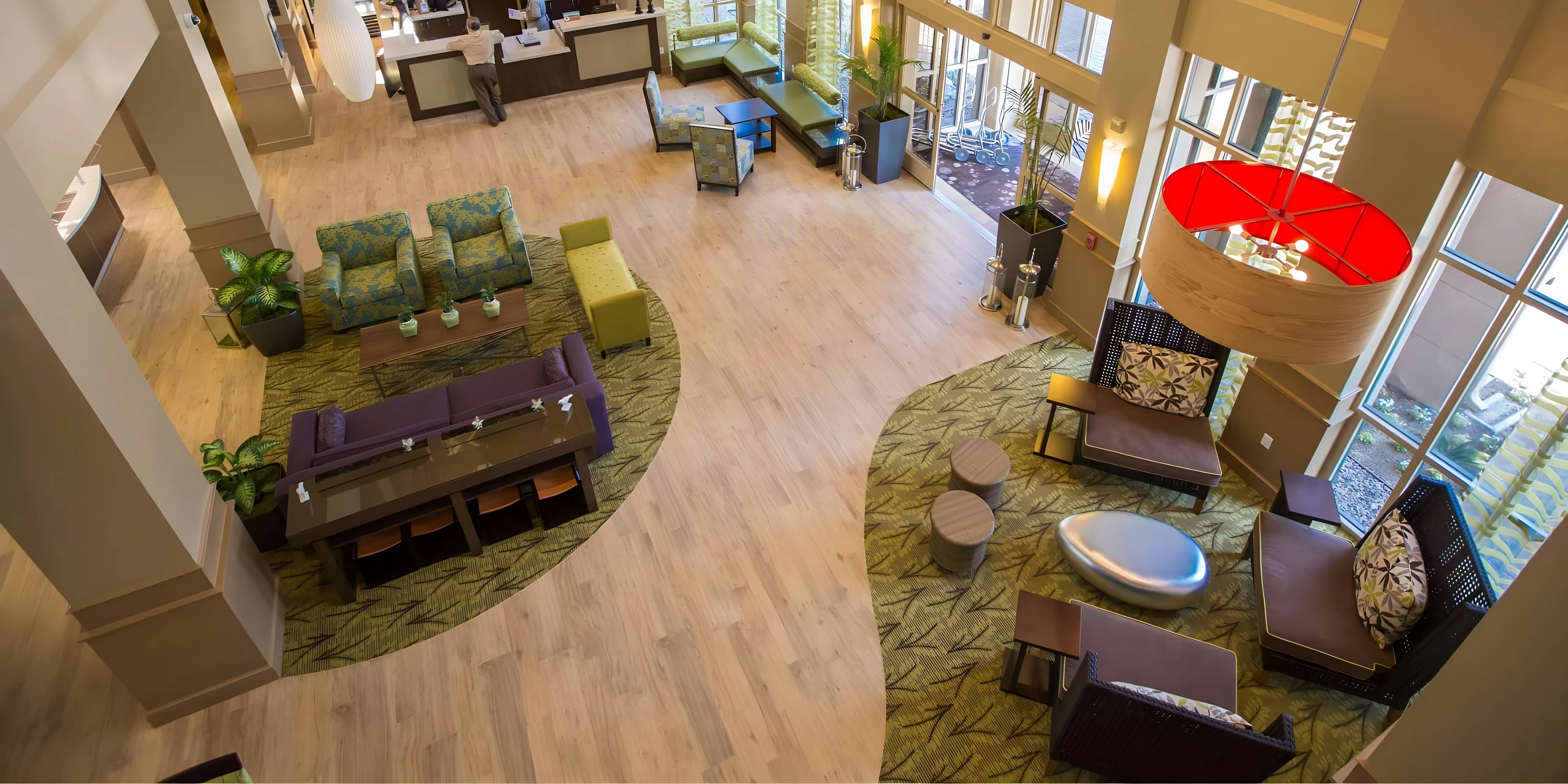 Overhead view of the renovated Hilton Garden Inn Montebello lobby with lounge seating and a red pendant