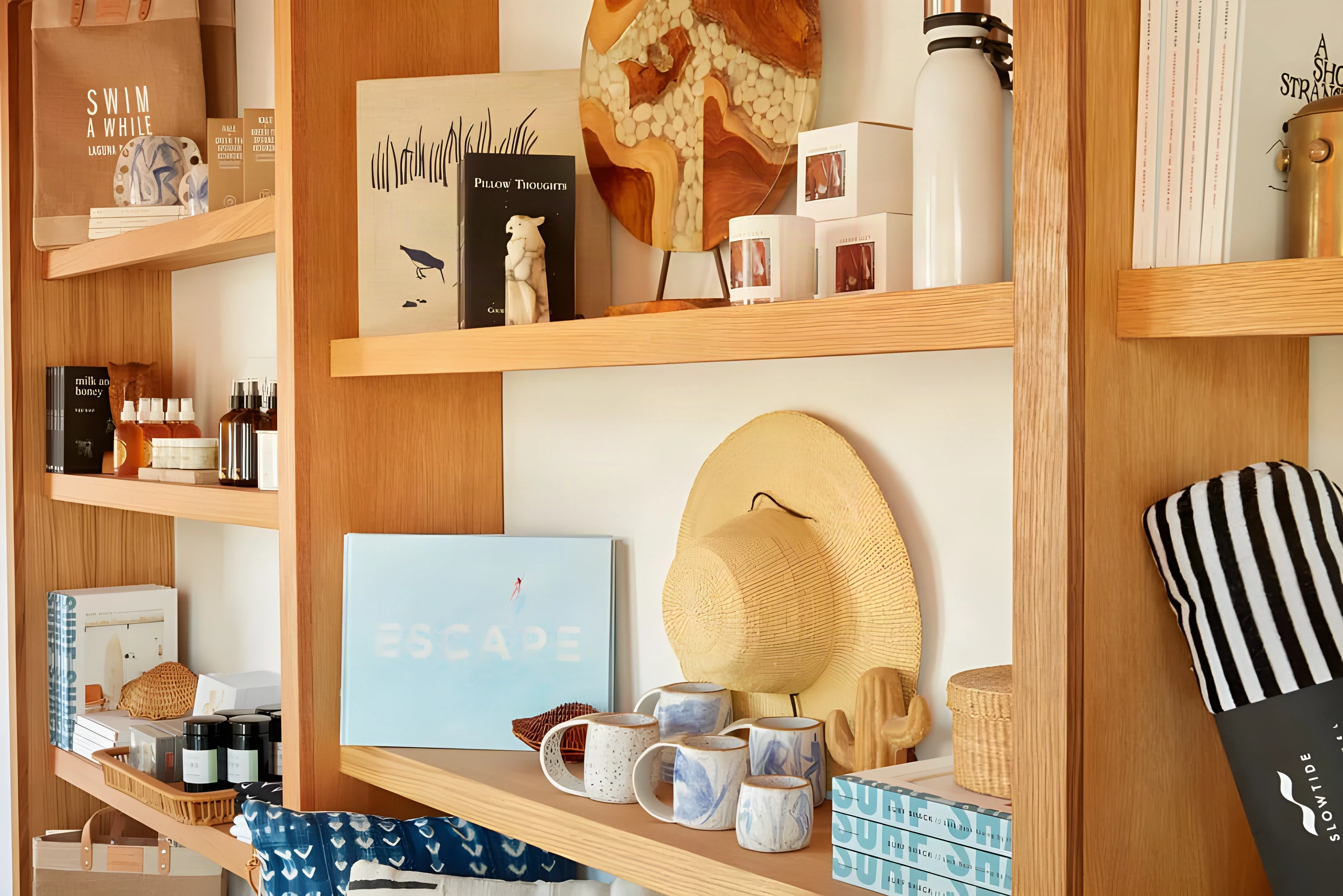Timber shelves stocked with books, hats and ceramics in the Laguna Beach hotel shop