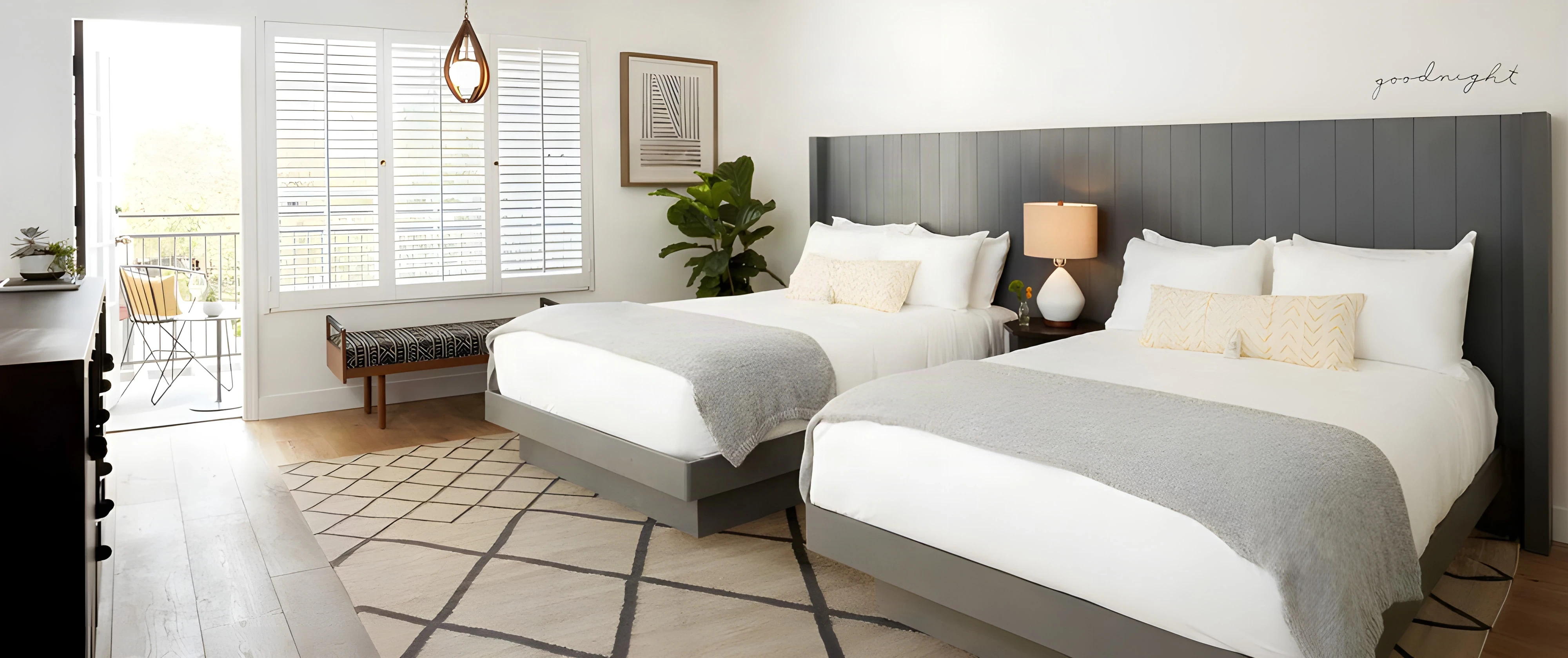 Twin queen guest room at The Landsby with grey headboards and shuttered windows