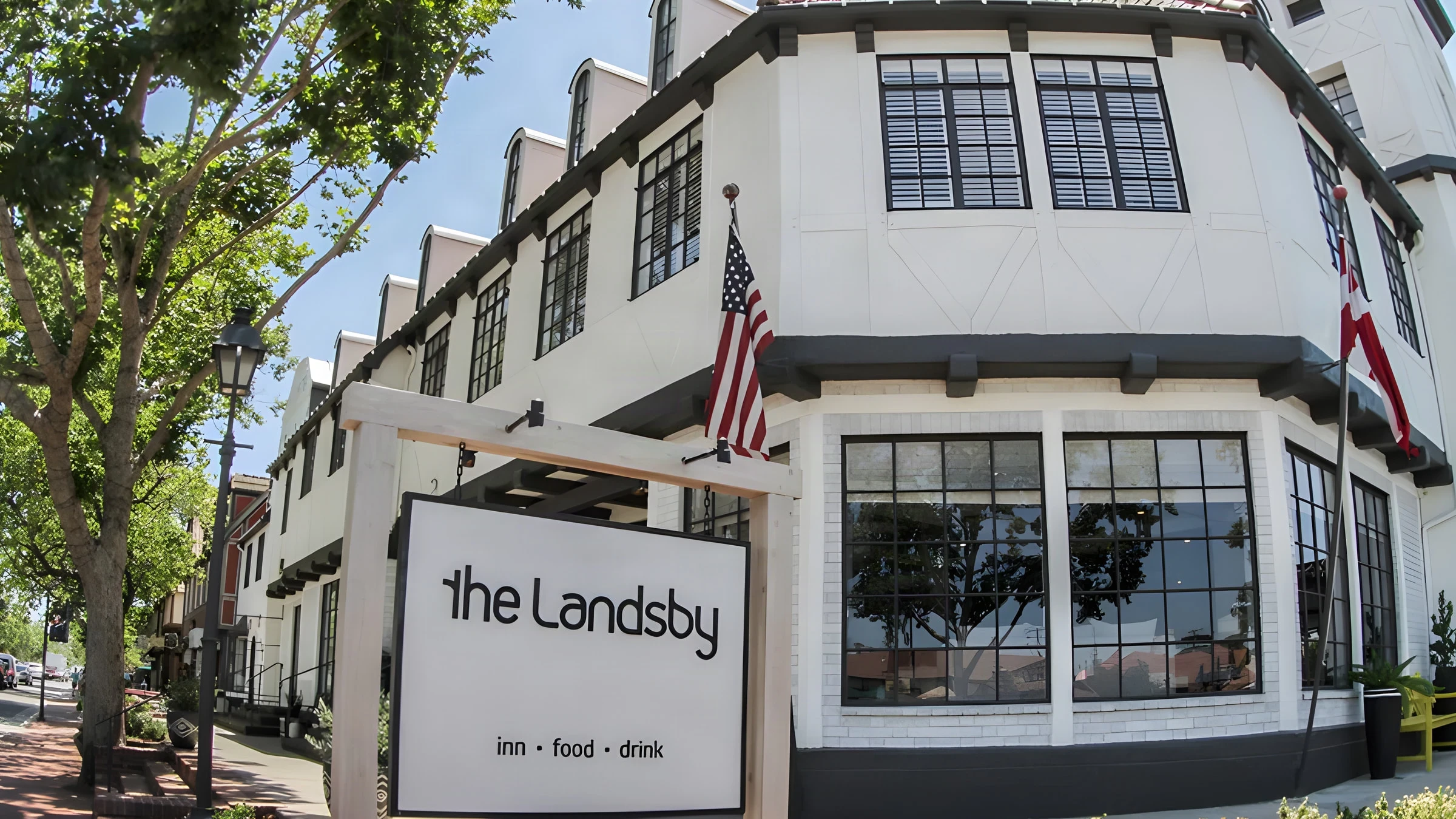 The Landsby street front with its sign, black-framed windows and flags in Solvang