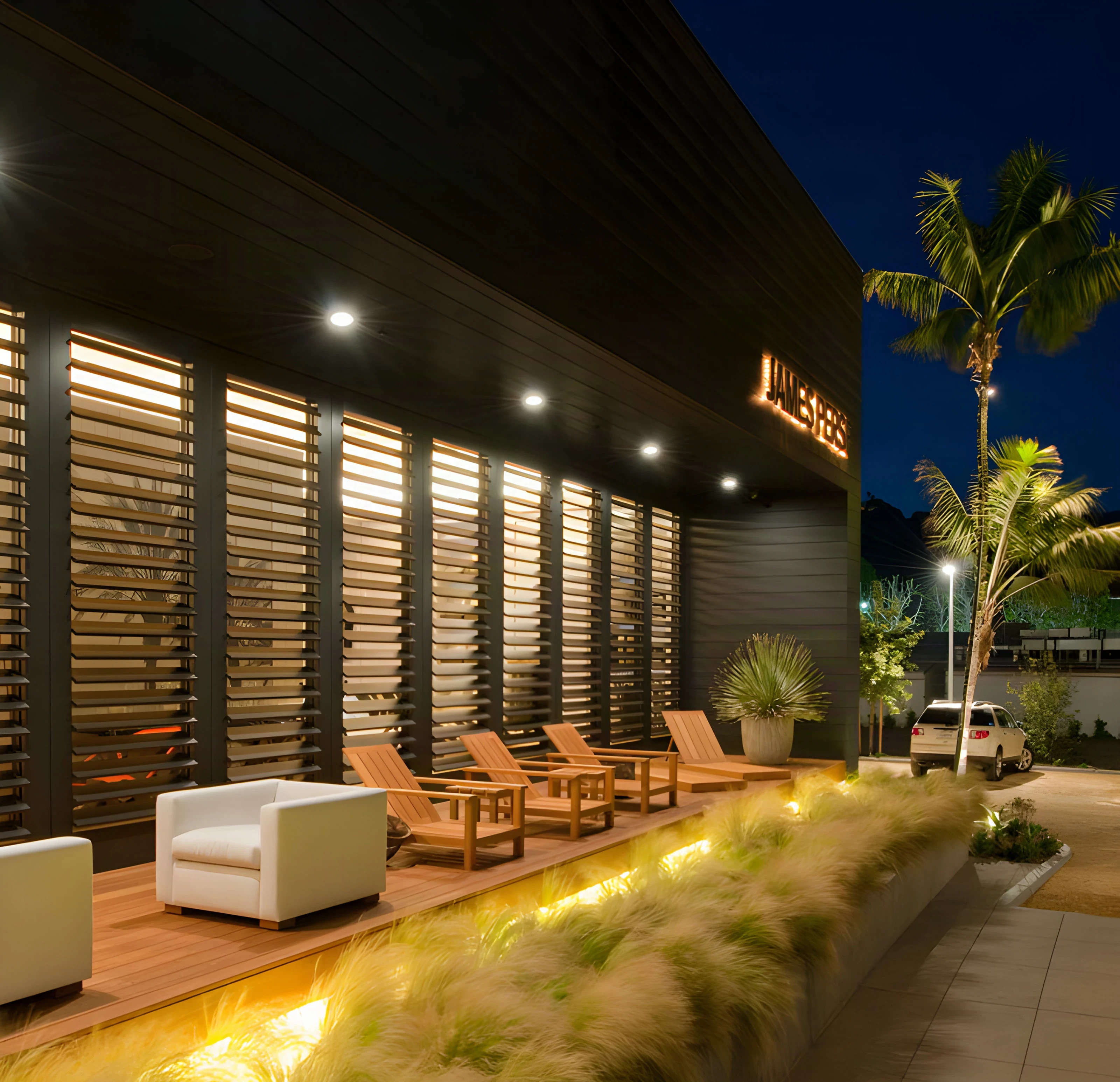 Backlit louvers and a landscaped lounge terrace at the Malibu pavilion in the evening