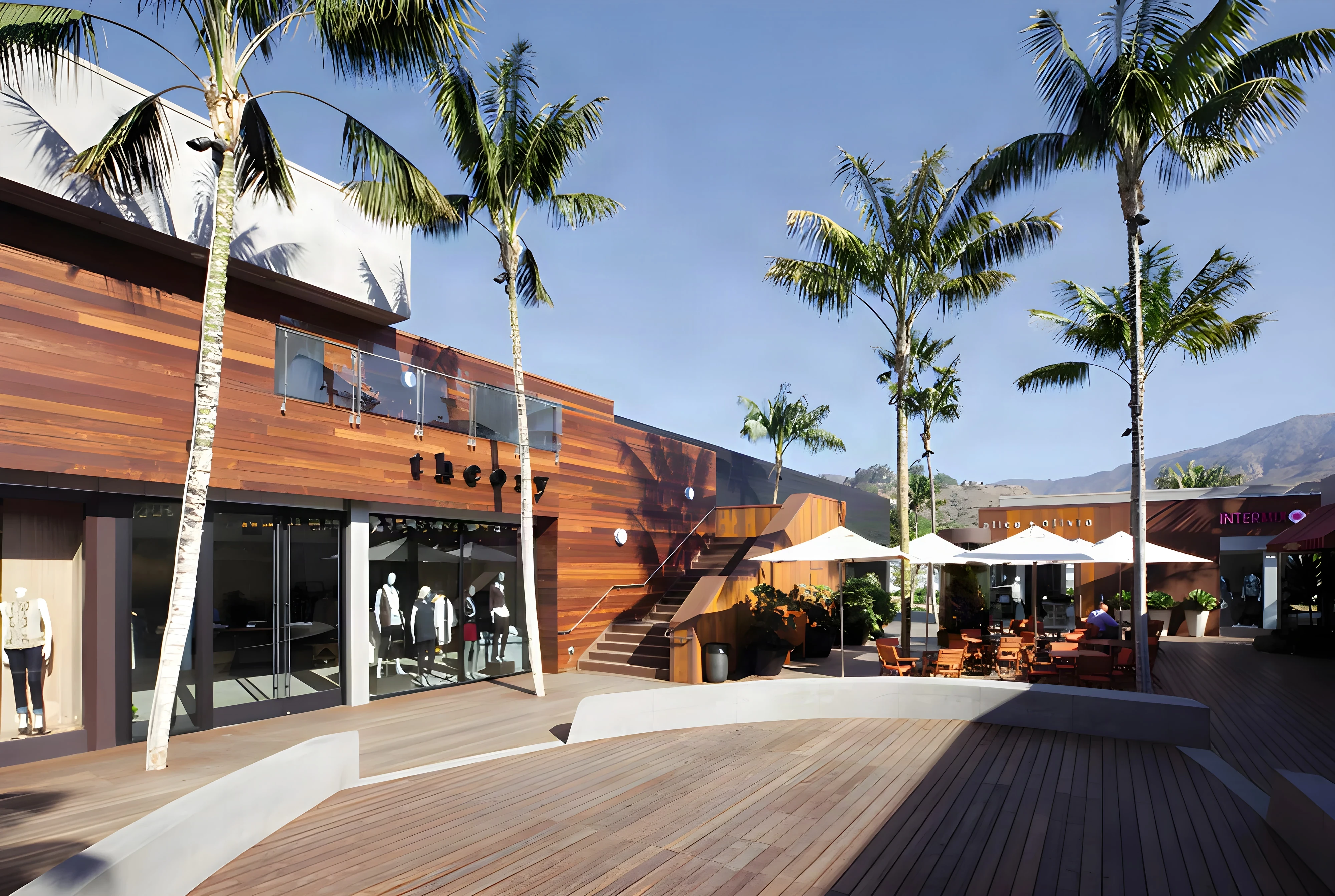 Cedar-clad storefronts, a timber stair and a sweeping ipe deck under tall palms at Malibu Lumber Yard