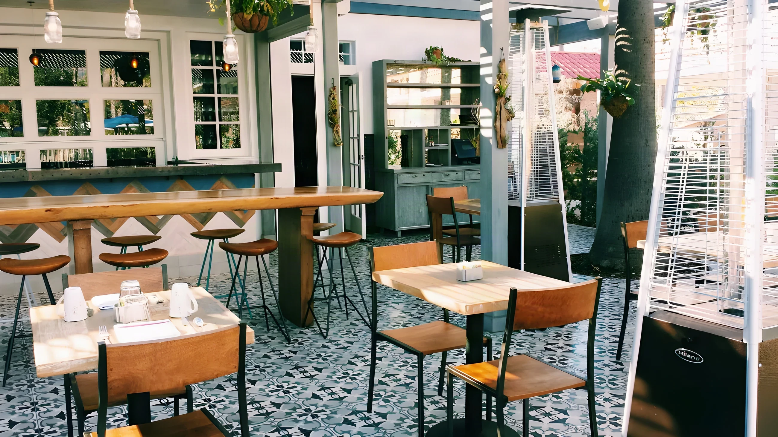 Outdoor bar at The Outpost with a tall timber counter and black and white tile floor