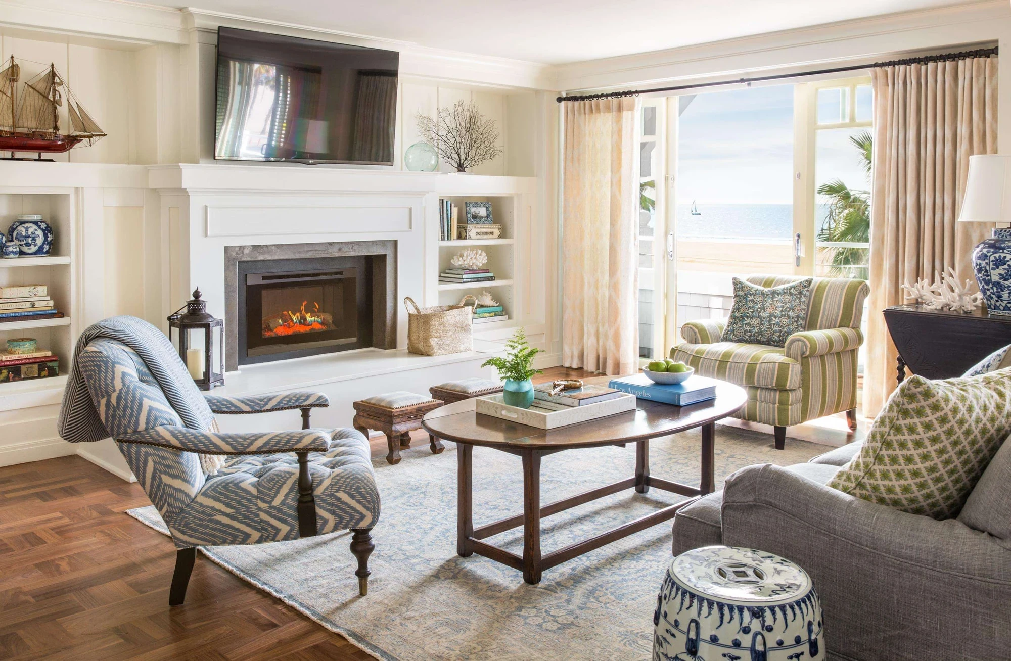 Renovated Shutters guest room with a fireplace, lounge chairs and a view to the beach