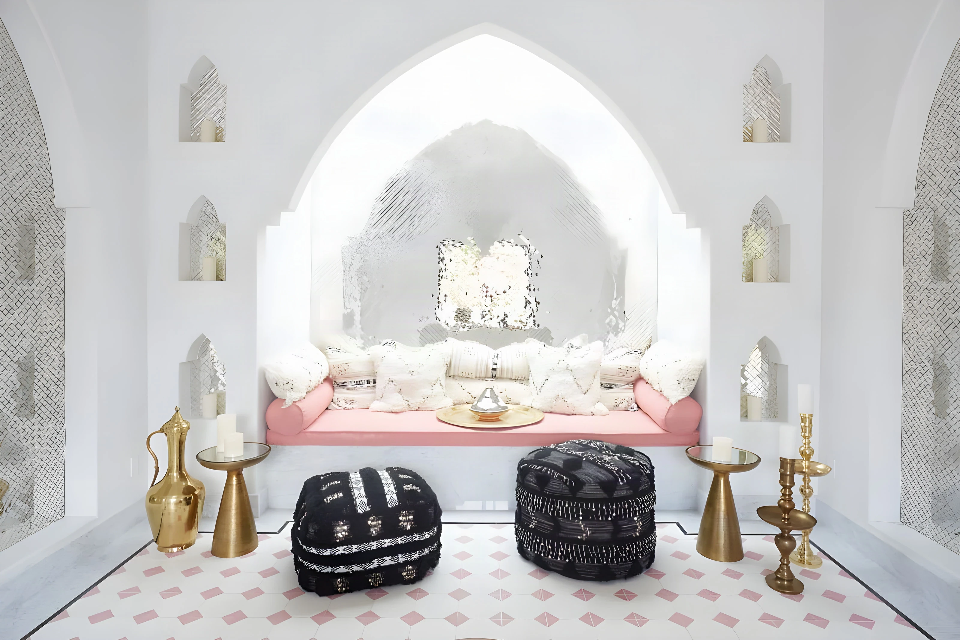 Black embroidered poufs before a pink daybed in the Indian Wells spa relaxation room